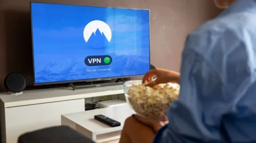 A relaxed scene at home with a person enjoying popcorn while watching a VPN-protected TV.